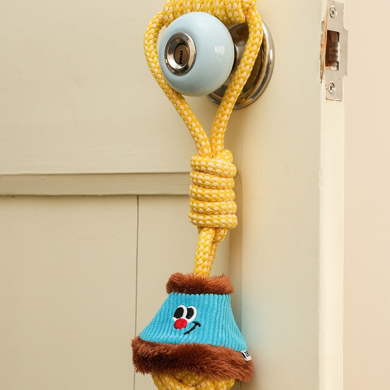 Yellow knotted rope toy with a blue and brown plush dog toy attached to a doorknob.