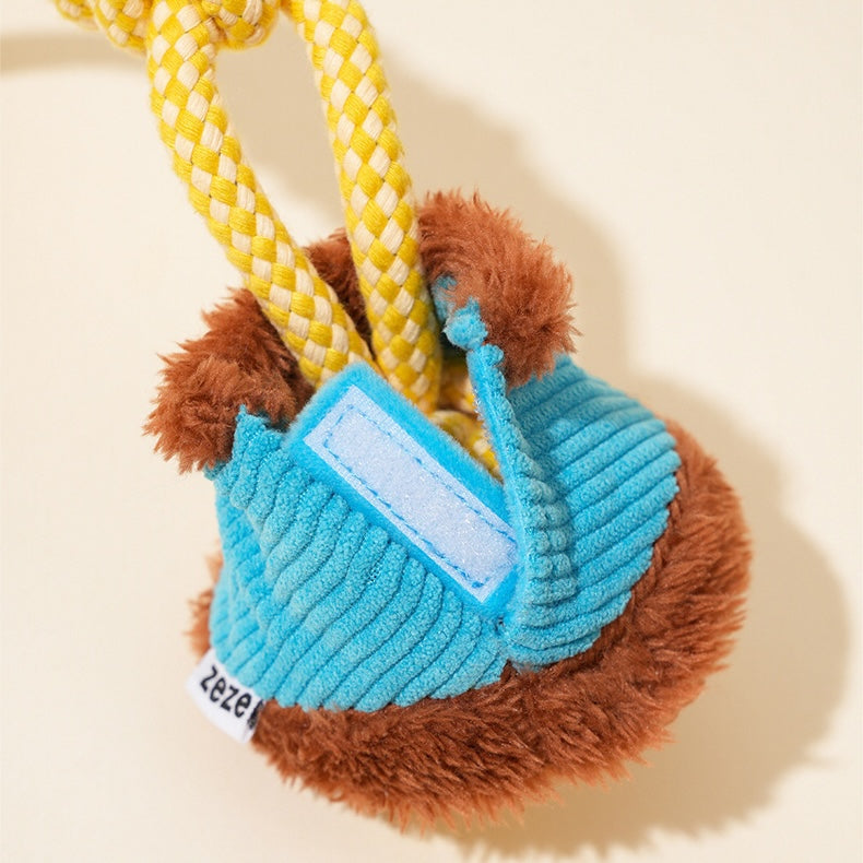 Dog toy with plush sloth and rope on a beige background