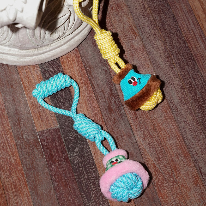 Colorful dog toy with rope and plush elements on a wooden floor