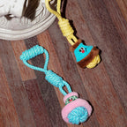 Colorful dog toy with rope and plush elements on a wooden floor