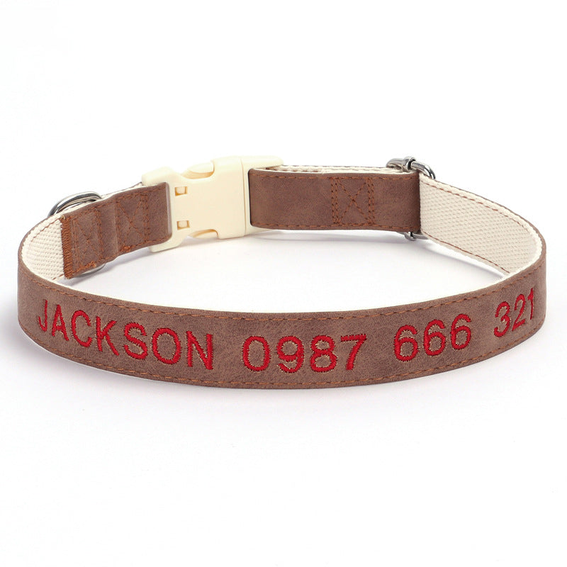 Dog collar with brown leather strap and red embroidered text on a white background
