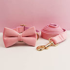 Pink dog collar with bow tie and matching leash on a pink background