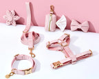 Pink pet accessories including a leash, collar, and harness on a white background with pink flowers.
